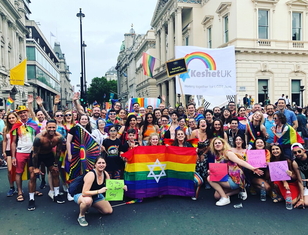 Group of KeshetUK and Friends from Pride in London 2019 - many people holding flags and banners smiling 